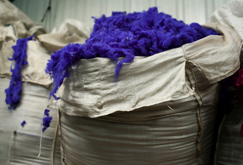 You see sacks of purple dyed wool.