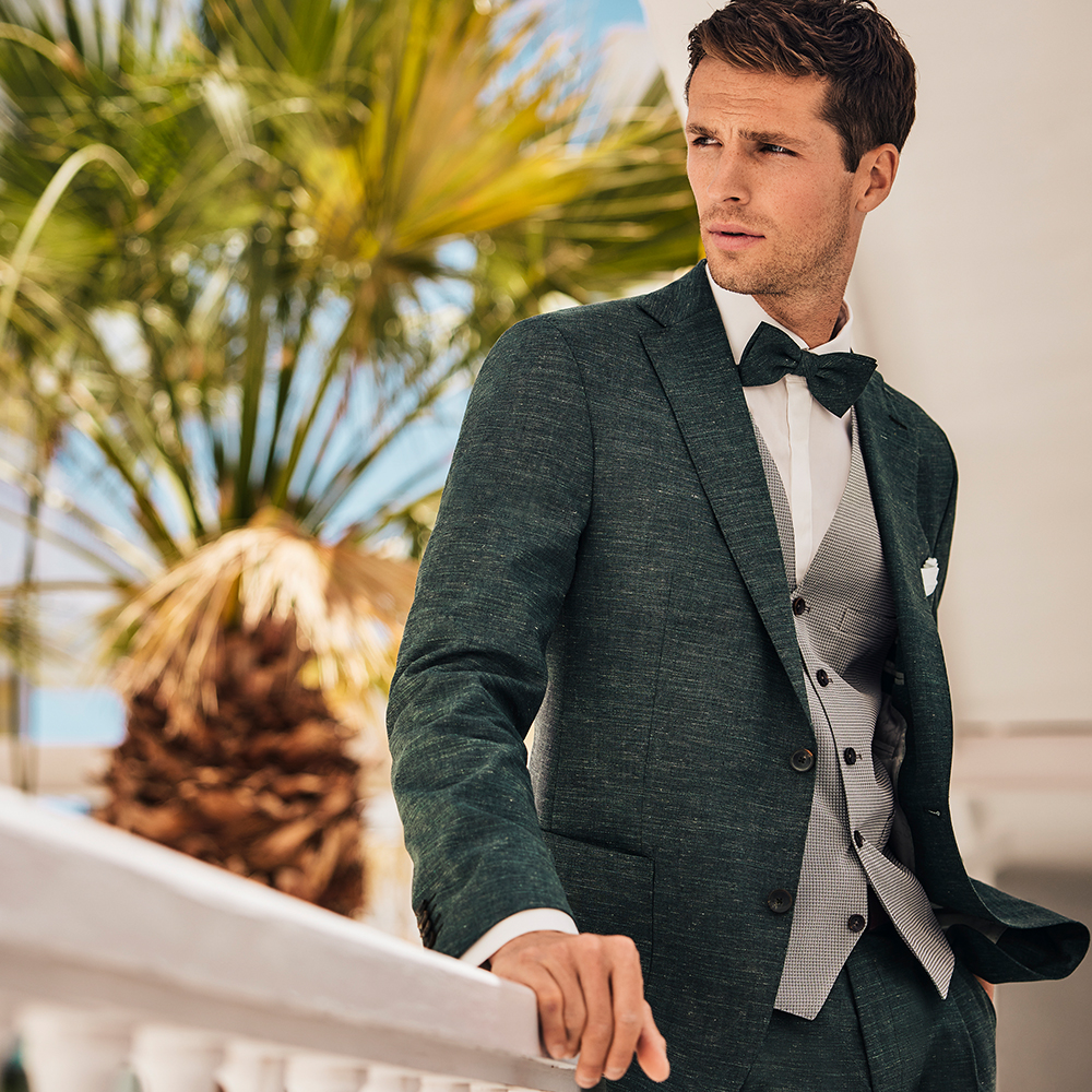 young man with brown hair in green wedding suit