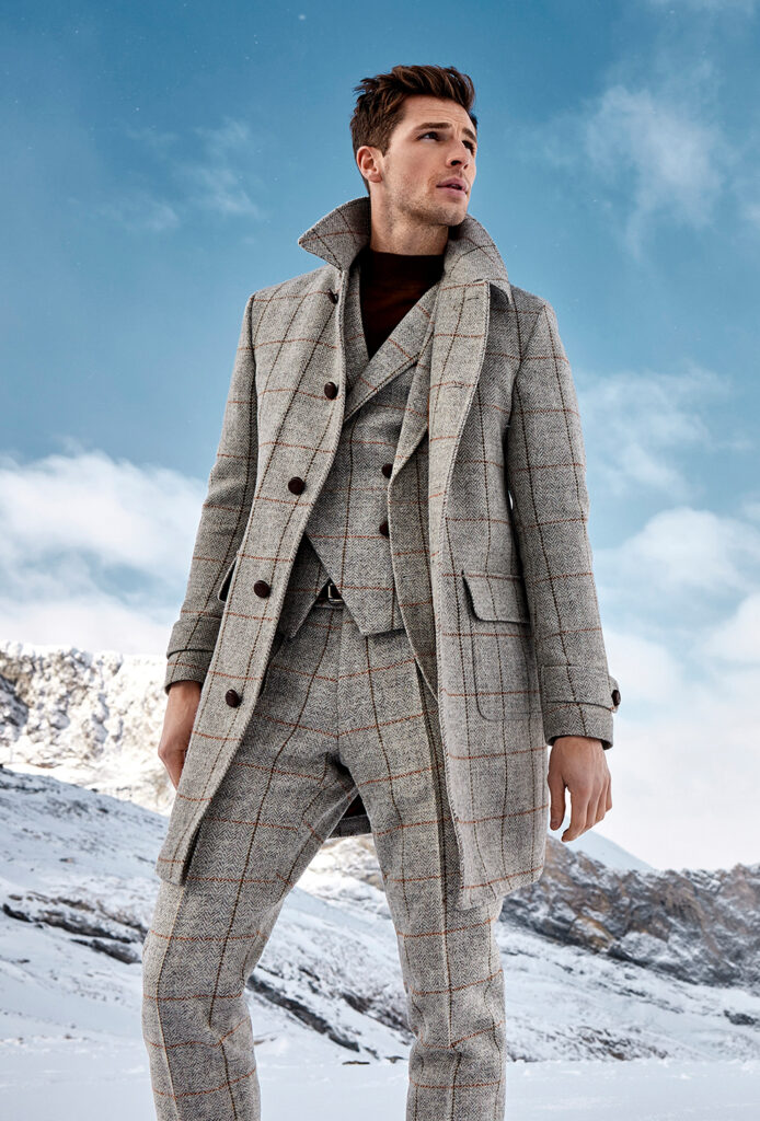 young man with brown hair in grey harris tweed coat